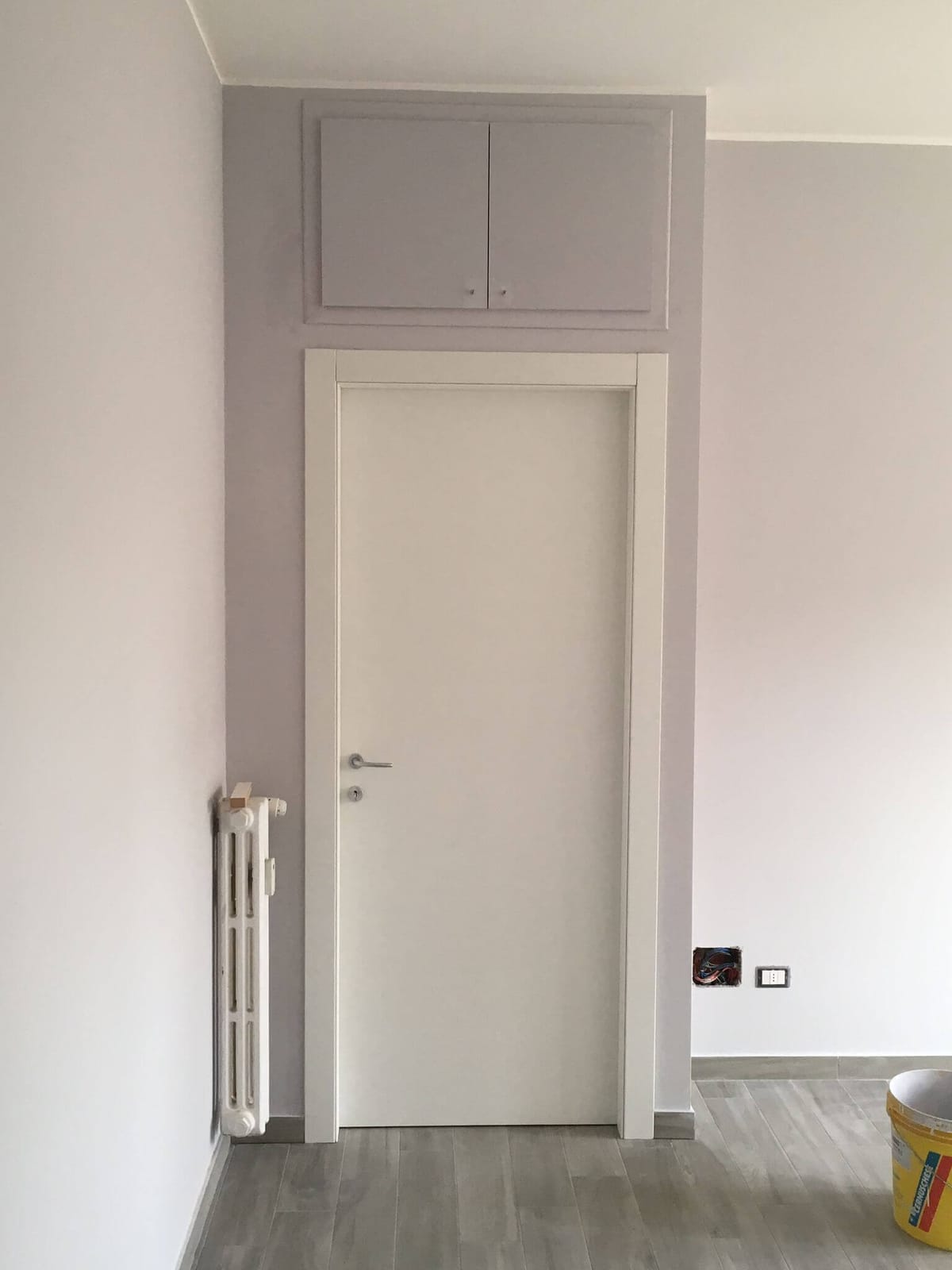 Appartamento ristrutturato con pareti tinteggiate, porta interna bianca e pavimento in gres effetto legno