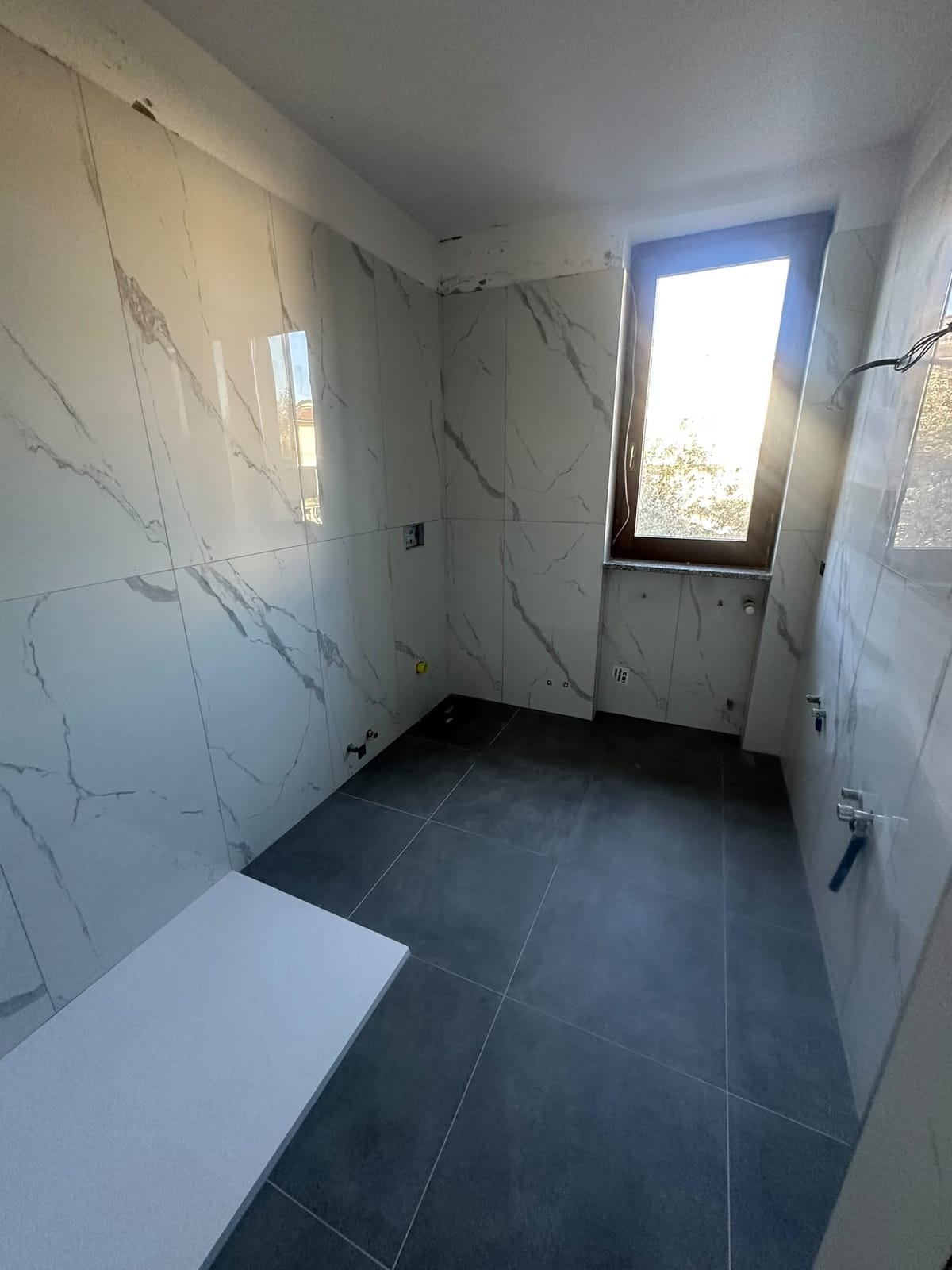Bagno con finestra e pavimento grigio – Bagni, lavoro di VGA Impresa Edile